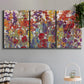 Three-panel canvas wall art featuring colorful floral arrangement, displayed in a modern living room above a sofa.