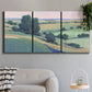 Three-panel canvas wall art featuring pastoral countryside with rocky outcrop, displayed in a modern living room above a sofa.