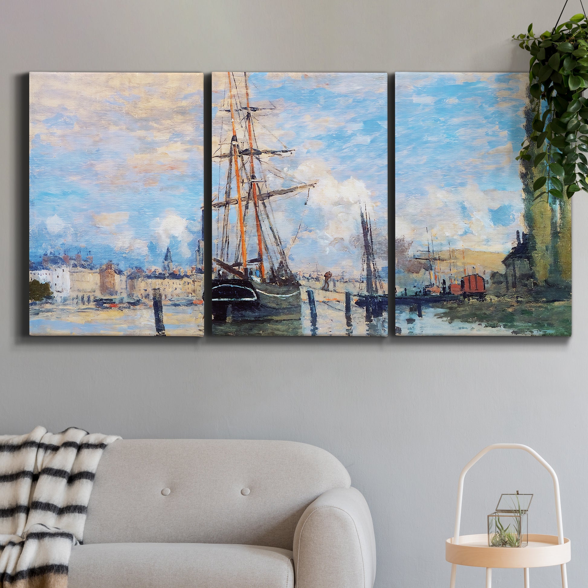Three-panel canvas wall art featuring busy river port scene, displayed in a modern living room above a sofa.