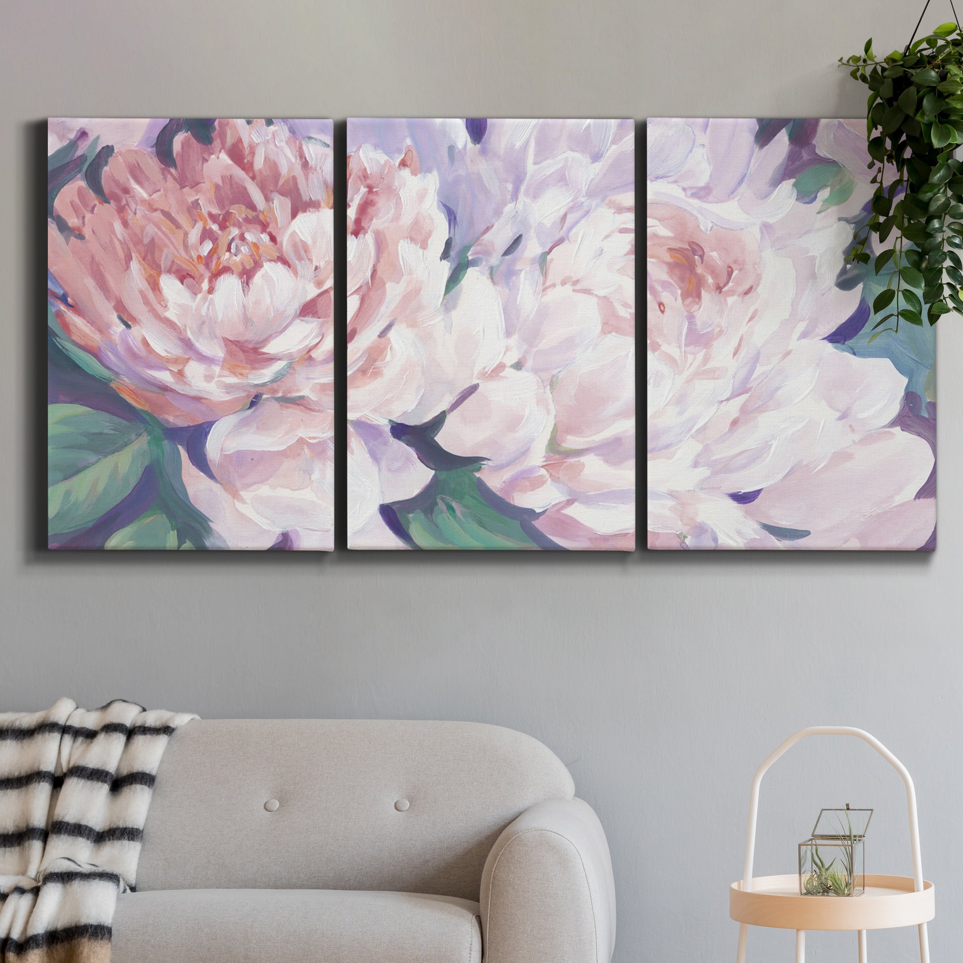 Three-panel canvas wall art featuring soft pink peonies in bloom, displayed in a modern living room above a sofa.