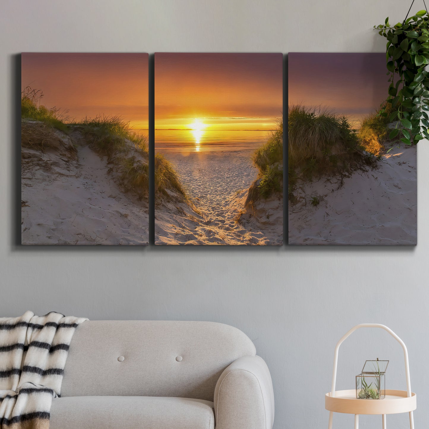 Three-panel canvas wall art featuring sunlit tropical path through greenery, displayed in a modern living room above a sofa.
