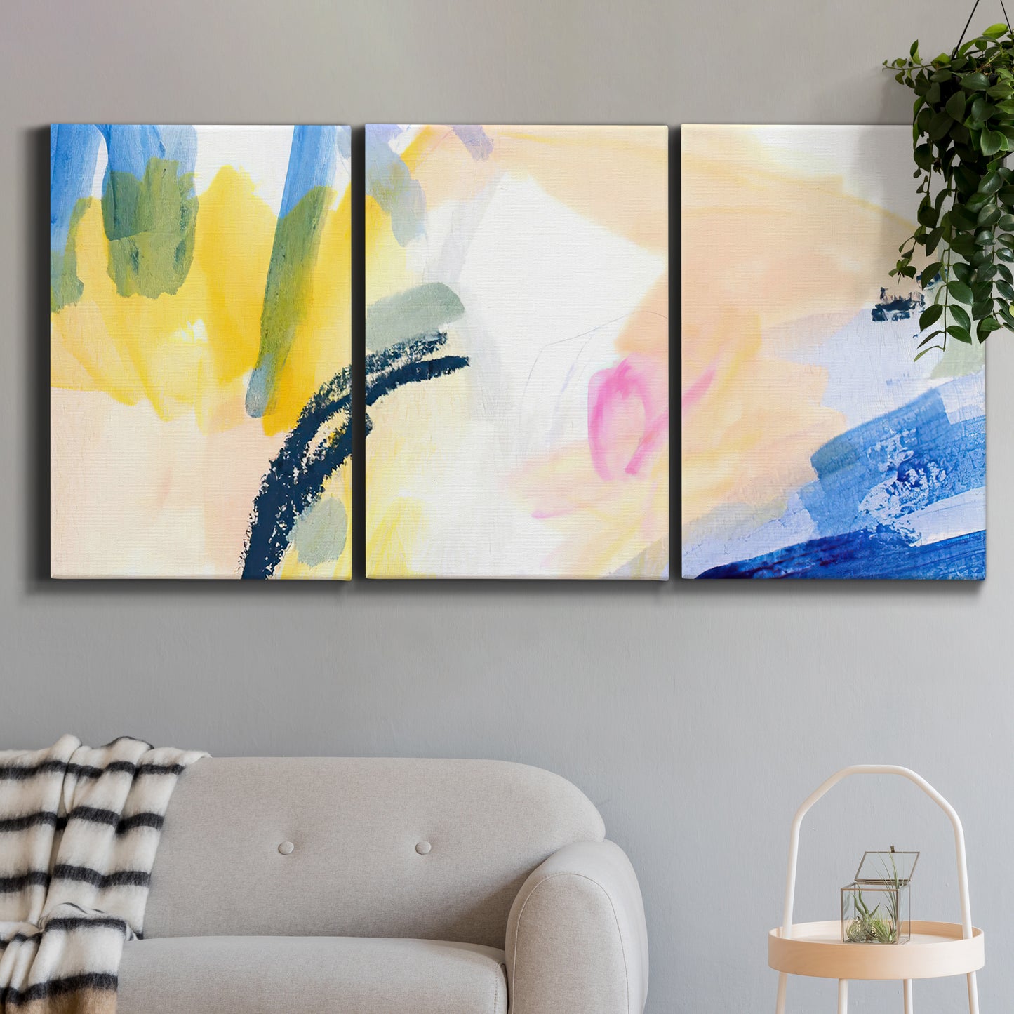Three-panel canvas wall art featuring bright abstract candy colored strokes, displayed in a modern living room above a sofa.