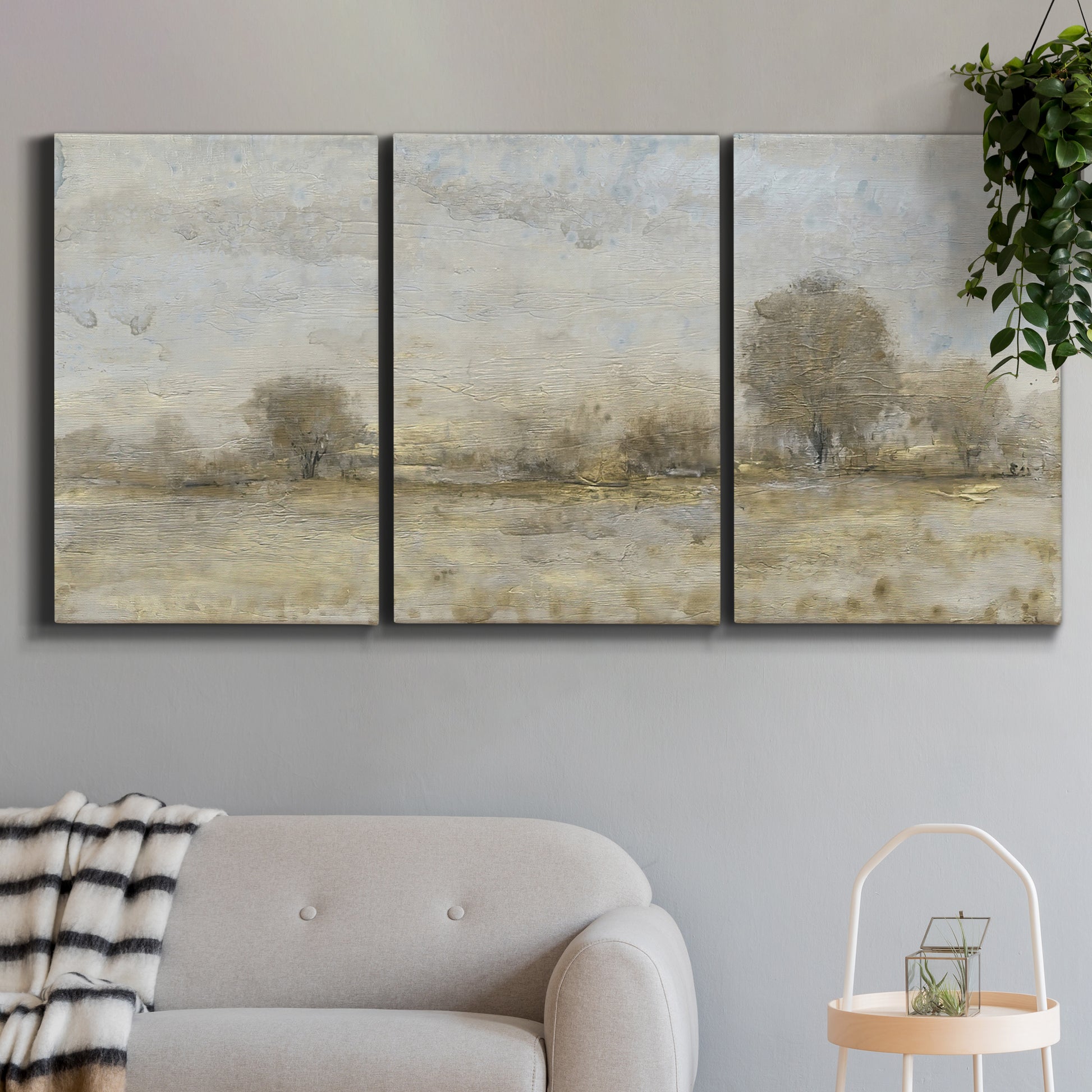 Three-panel canvas wall art featuring late season rural harvest fields, displayed in a modern living room above a sofa.