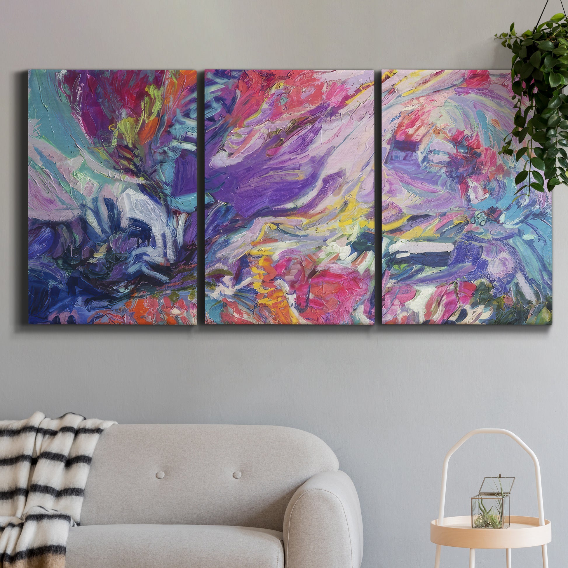 Three-panel canvas wall art featuring expressive abstract with layered color, displayed in a modern living room above a sofa.