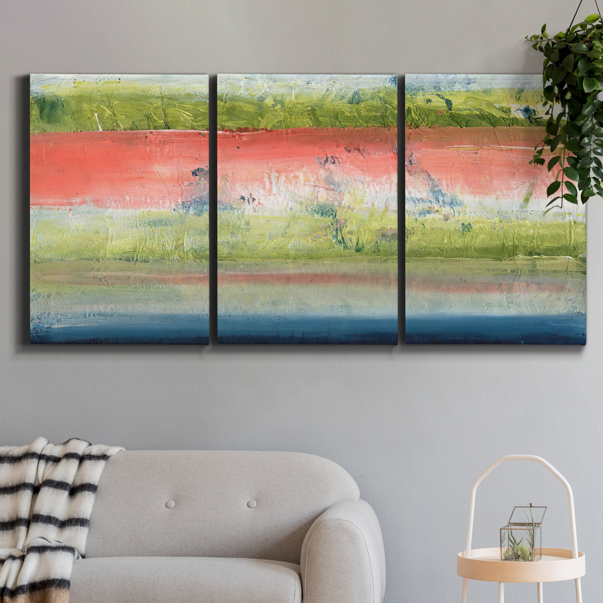 Three-panel canvas wall art featuring layered abstract color banding, displayed in a modern living room above a sofa.