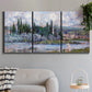 Three-panel canvas wall art featuring summer village view along river, displayed in a modern living room above a sofa.