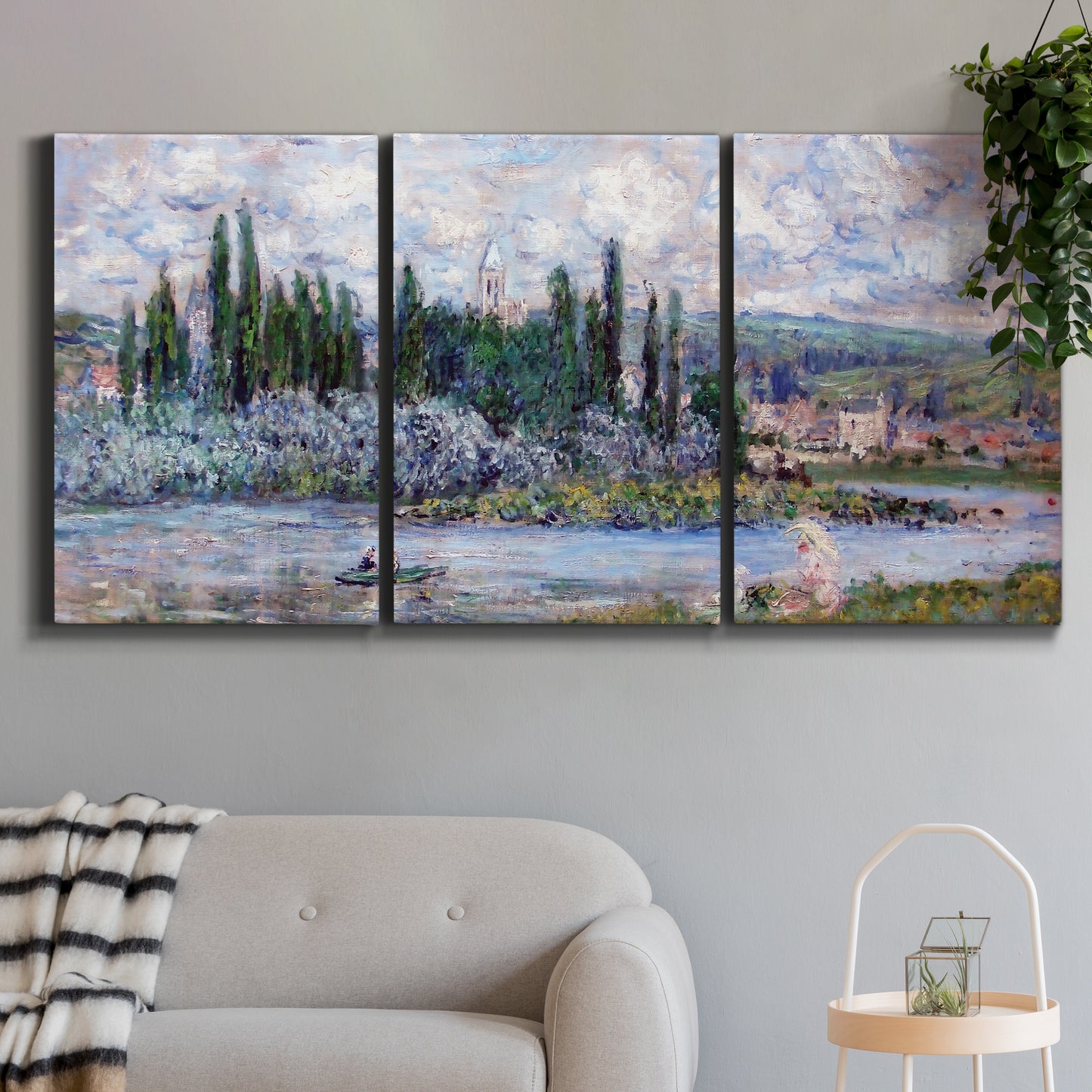 Three-panel canvas wall art featuring summer village view along river, displayed in a modern living room above a sofa.