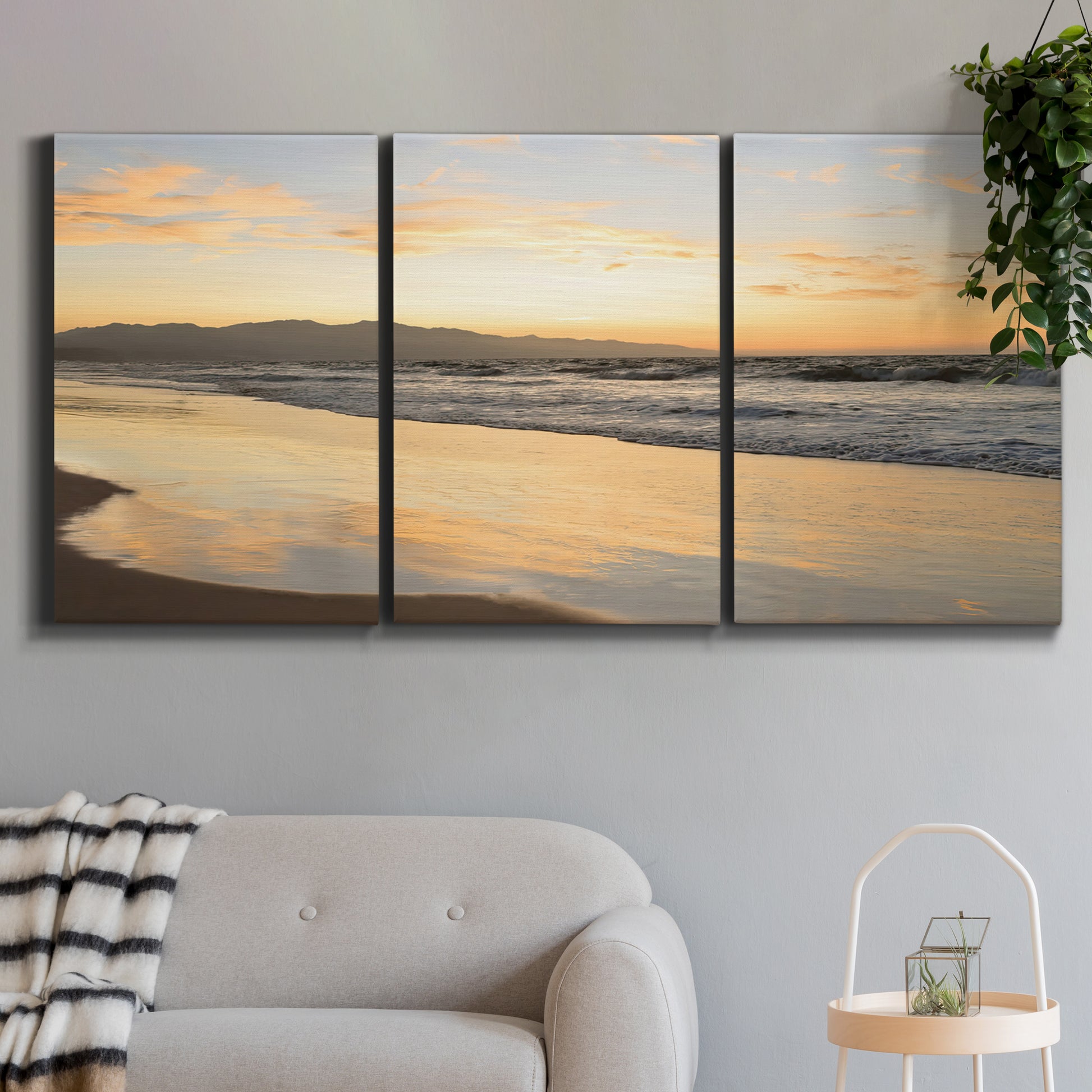 Three-panel canvas wall art featuring quiet tropical shoreline at low tide, displayed in a modern living room above a sofa.
