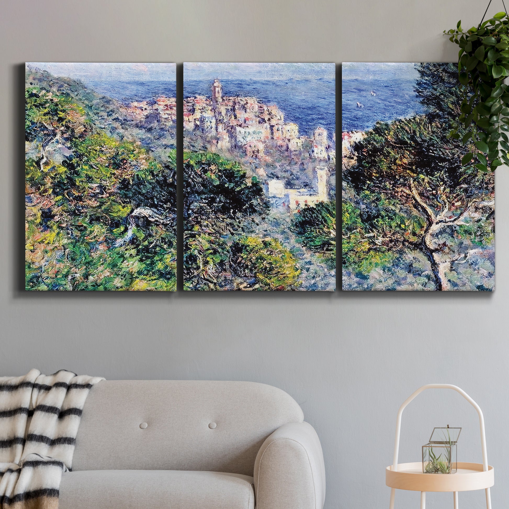 Three-panel canvas wall art featuring coastal hillside overlooking monaco, displayed in a modern living room above a sofa.