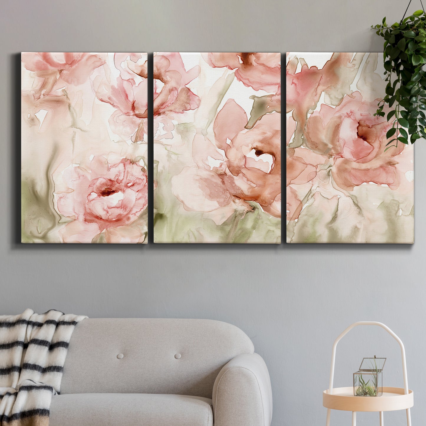 Three-panel canvas wall art featuring spring floral blossoms in bloom, displayed in a modern living room above a sofa.