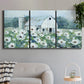 Three-panel canvas wall art featuring pastoral farmland with open fields, displayed in a modern living room above a sofa.