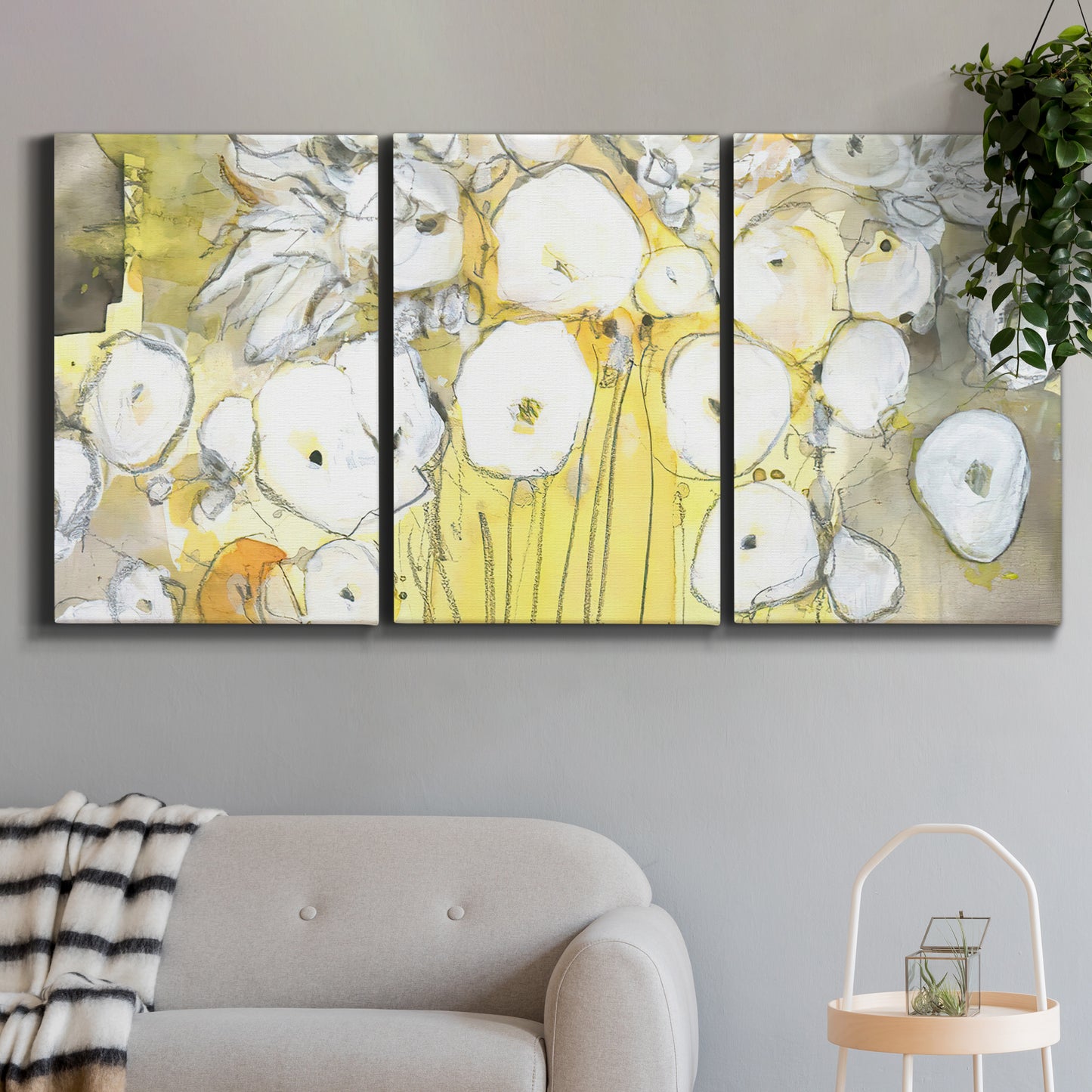 Three-panel canvas wall art featuring vintage inspired floral abstraction, displayed in a modern living room above a sofa.