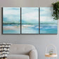 Three-panel canvas wall art featuring sunset silhouette over coastal water, displayed in a modern living room above a sofa.