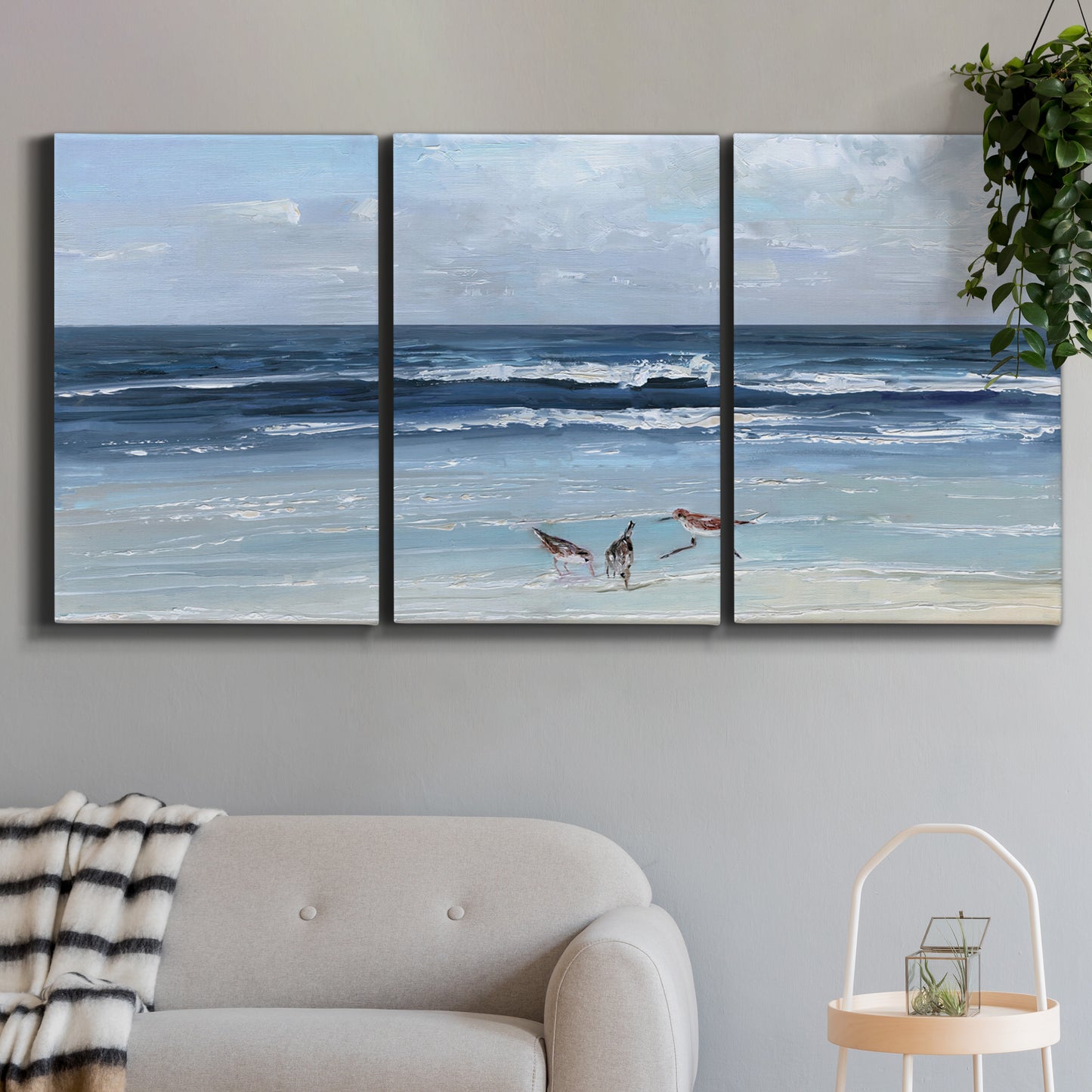 Three-panel canvas wall art featuring loose farmhouse style floral painting, displayed in a modern living room above a sofa.