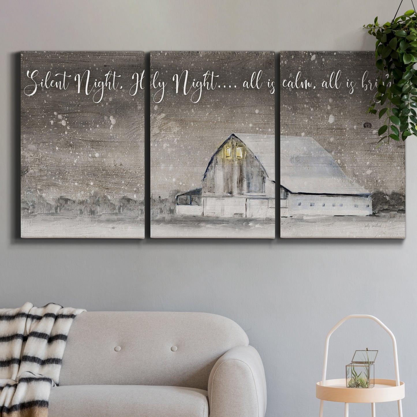Three-panel canvas wall art featuring rustic winter holiday text art, displayed in a modern living room above a sofa.