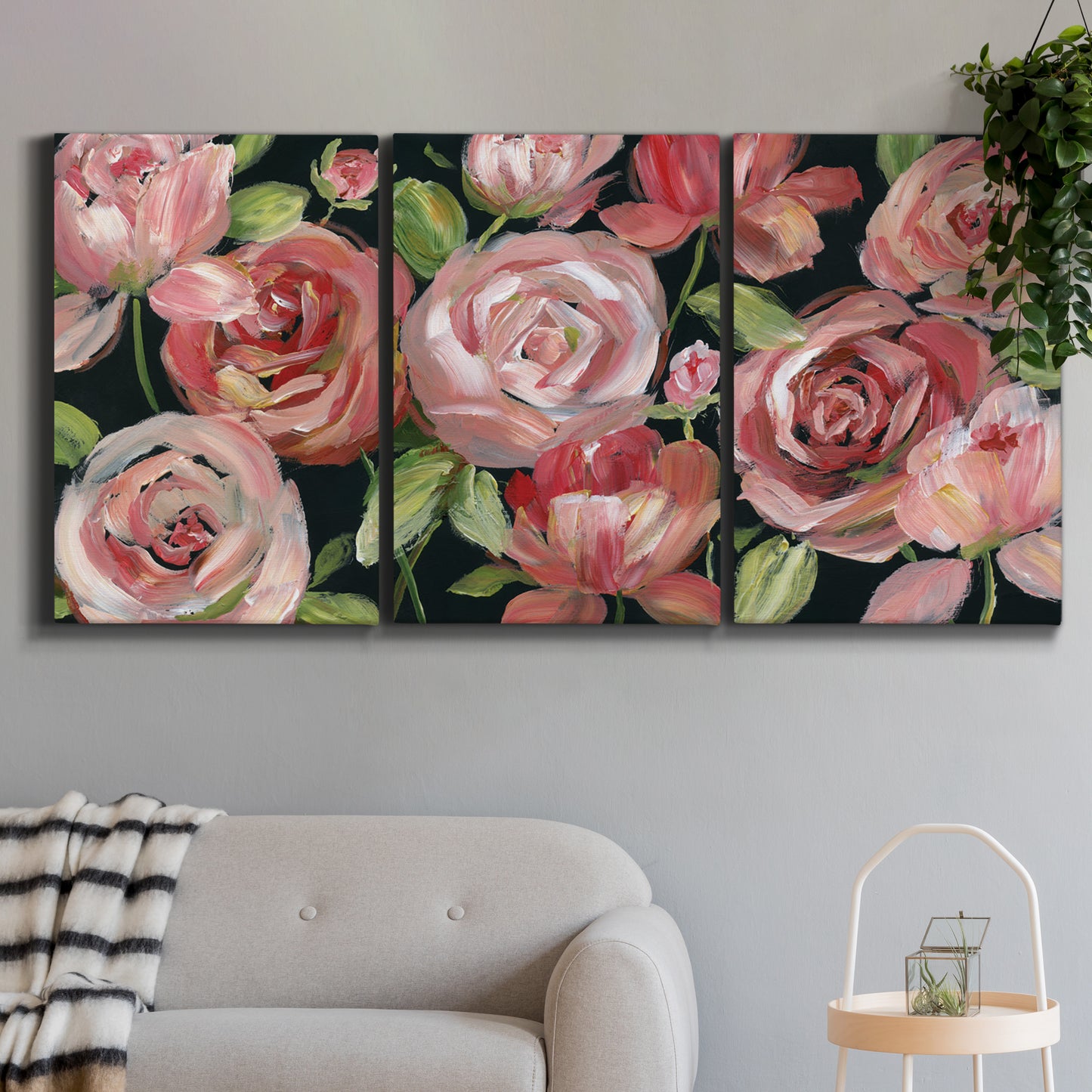 Three-panel canvas wall art featuring bold red floral abstraction, displayed in a modern living room above a sofa.