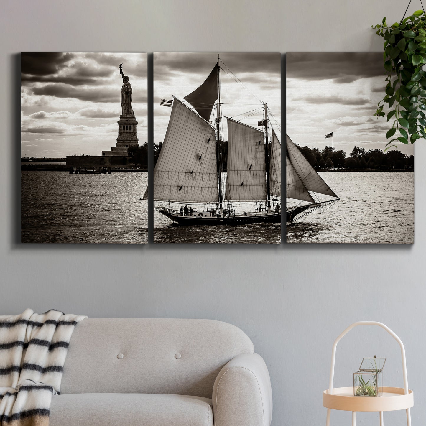 Three-panel canvas wall art featuring historic sailing ships photograph, displayed in a modern living room above a sofa.