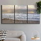 Three-panel canvas wall art featuring calm coastal shoreline seascape, displayed in a modern living room above a sofa.
