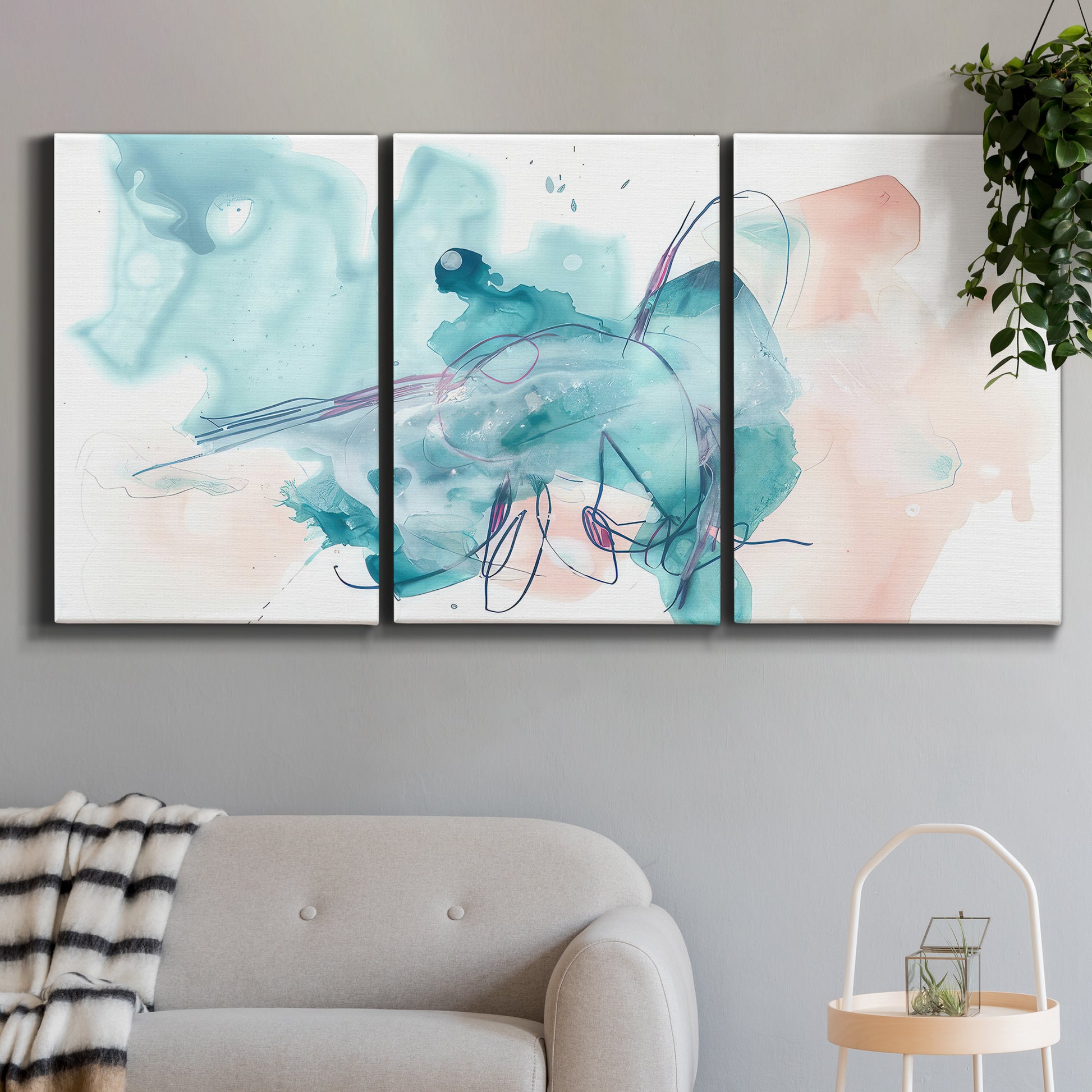 Three-panel canvas wall art featuring soft abstract watercolor forms, displayed in a modern living room above a sofa.