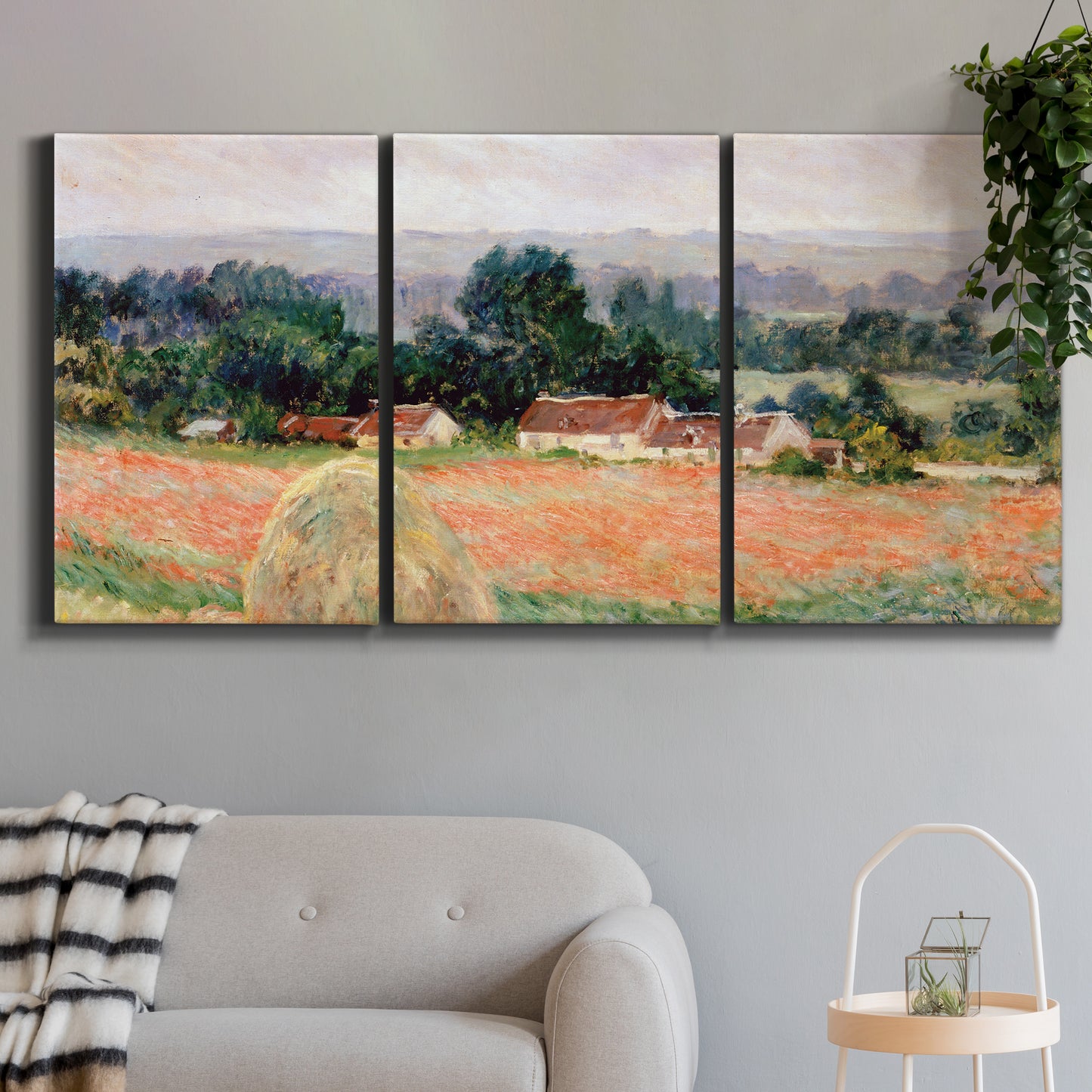 Three-panel canvas wall art featuring haystacks arranged in rural field, displayed in a modern living room above a sofa.