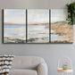 Three-panel canvas wall art featuring coastal shoreline landscape study, displayed in a modern living room above a sofa.