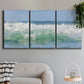 Three-panel canvas wall art featuring coastal waves breaking ashore, displayed in a modern living room above a sofa.