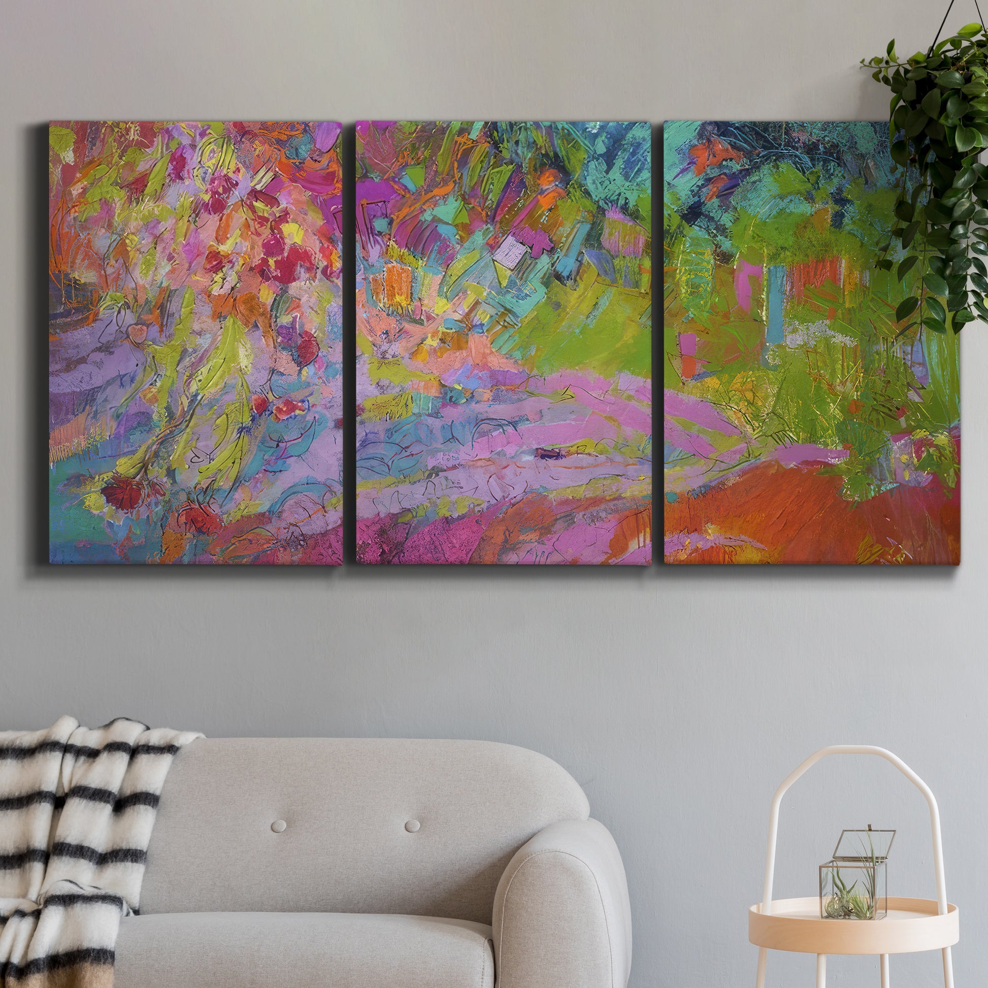 Three-panel canvas wall art featuring vibrant abstract with dramatic motion, displayed in a modern living room above a sofa.