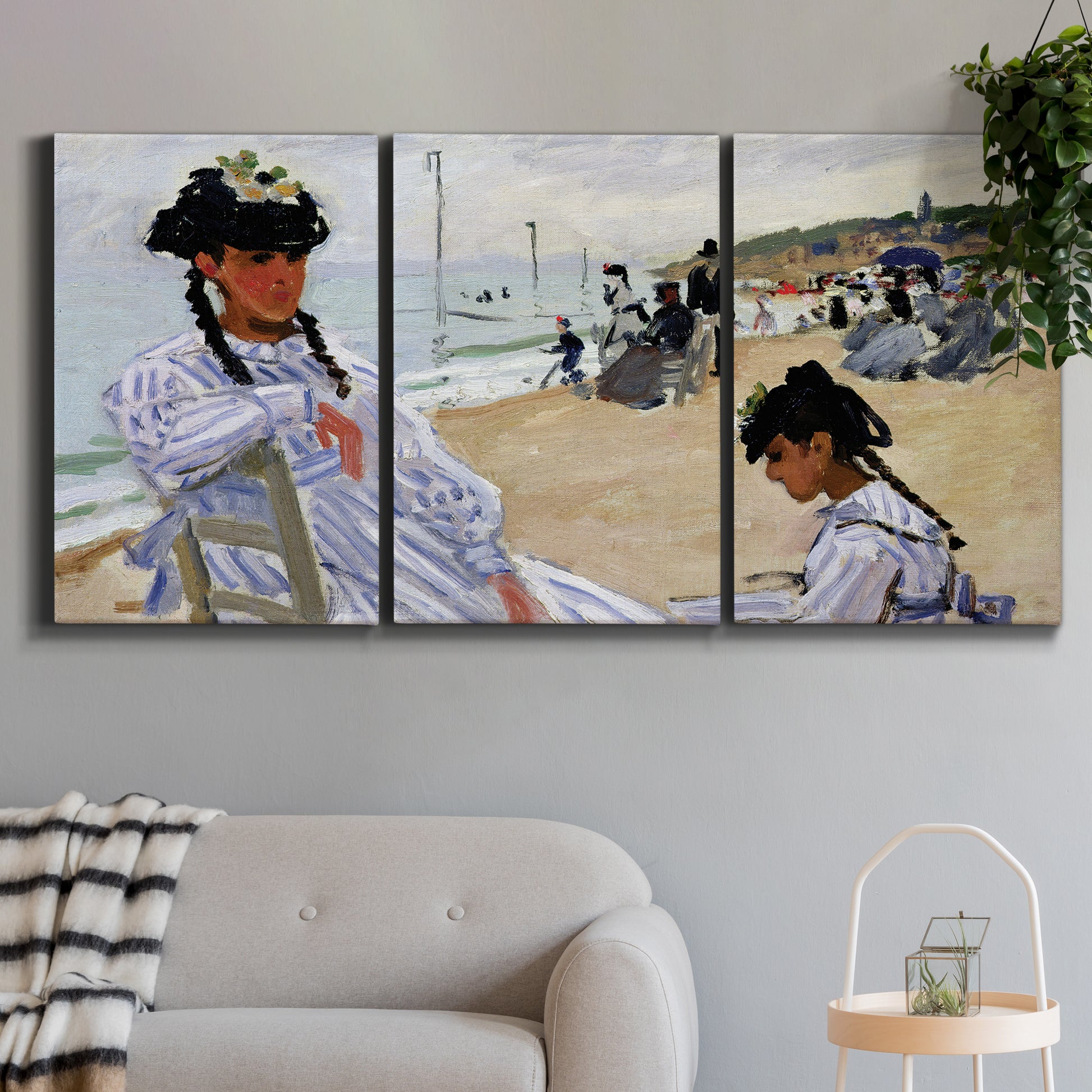 Three-panel canvas wall art featuring figures walking along sandy beach, displayed in a modern living room above a sofa.