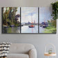 Three-panel canvas wall art featuring river view with boats and reflections, displayed in a modern living room above a sofa.