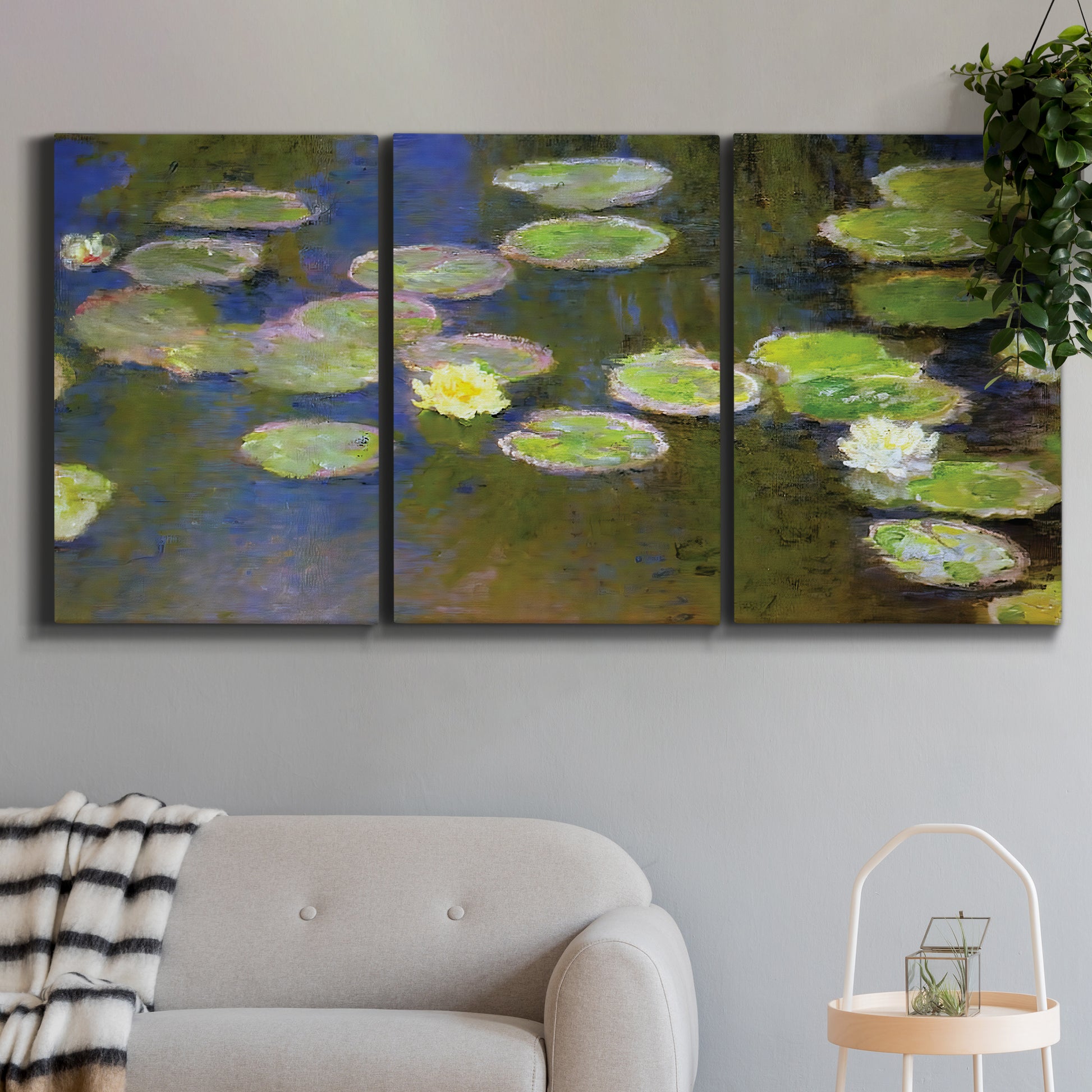 Three-panel canvas wall art featuring yellow and white water lilies, displayed in a modern living room above a sofa.