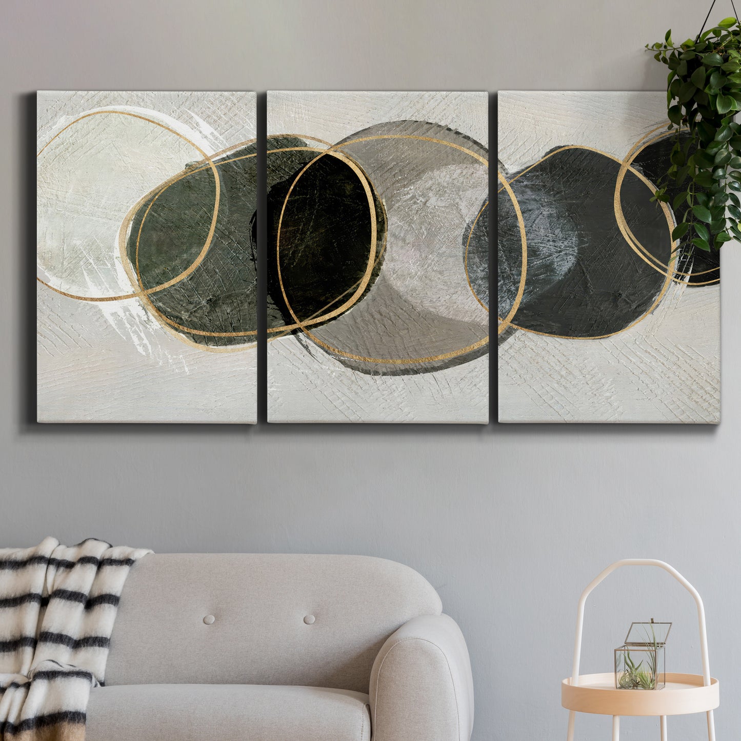 Three-panel canvas wall art featuring smooth abstract river stone forms, displayed in a modern living room above a sofa.