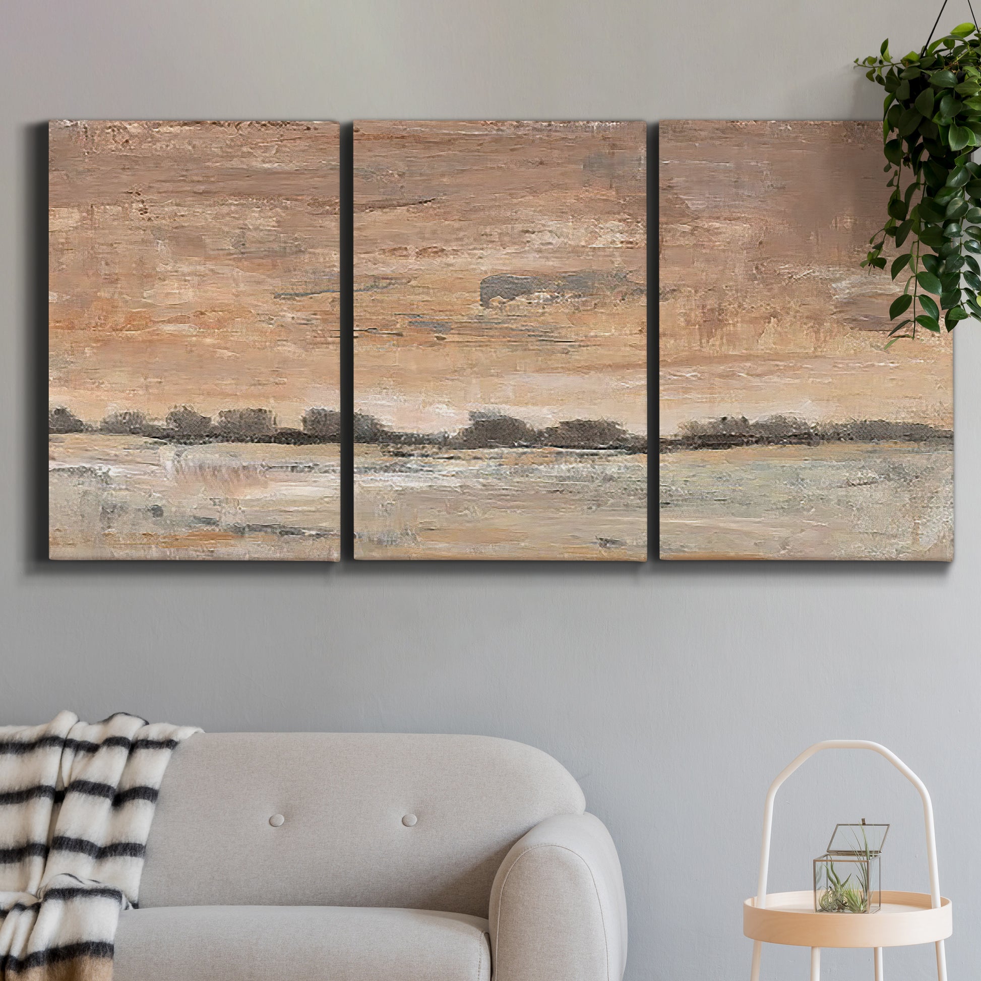 Three-panel canvas wall art featuring soft early evening landscape light, displayed in a modern living room above a sofa.