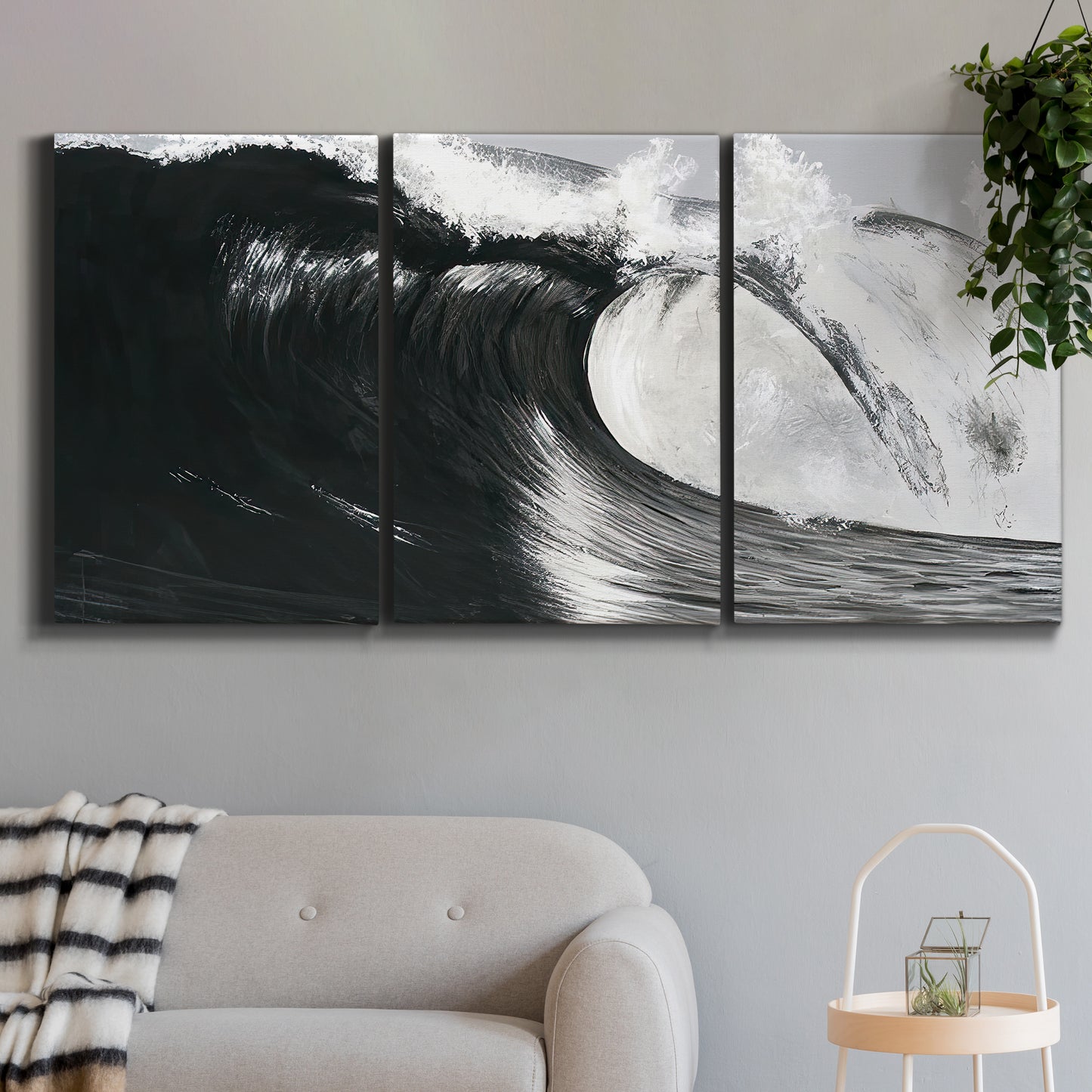 Three-panel canvas wall art featuring black and white crashing ocean waves, displayed in a modern living room above a sofa.