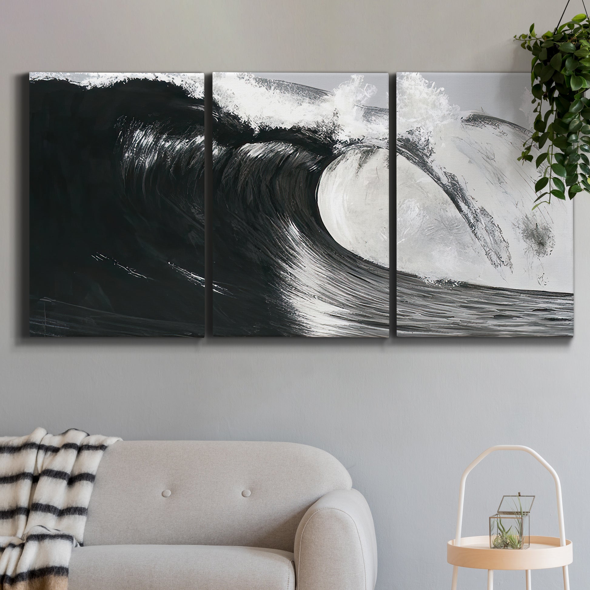 Three-panel canvas wall art featuring black and white crashing ocean waves, displayed in a modern living room above a sofa.