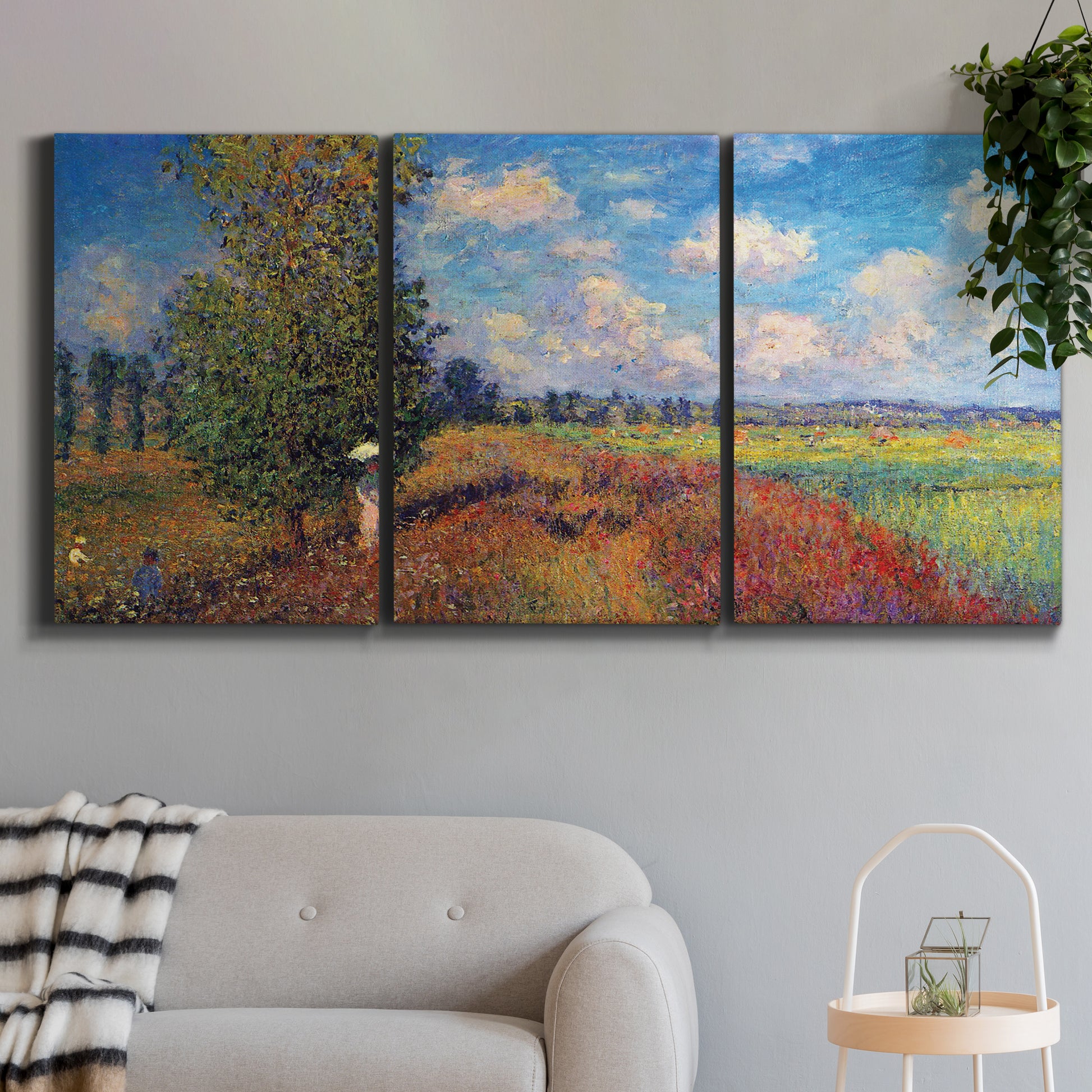 Three-panel canvas wall art featuring summer poppy field in bloom, displayed in a modern living room above a sofa.