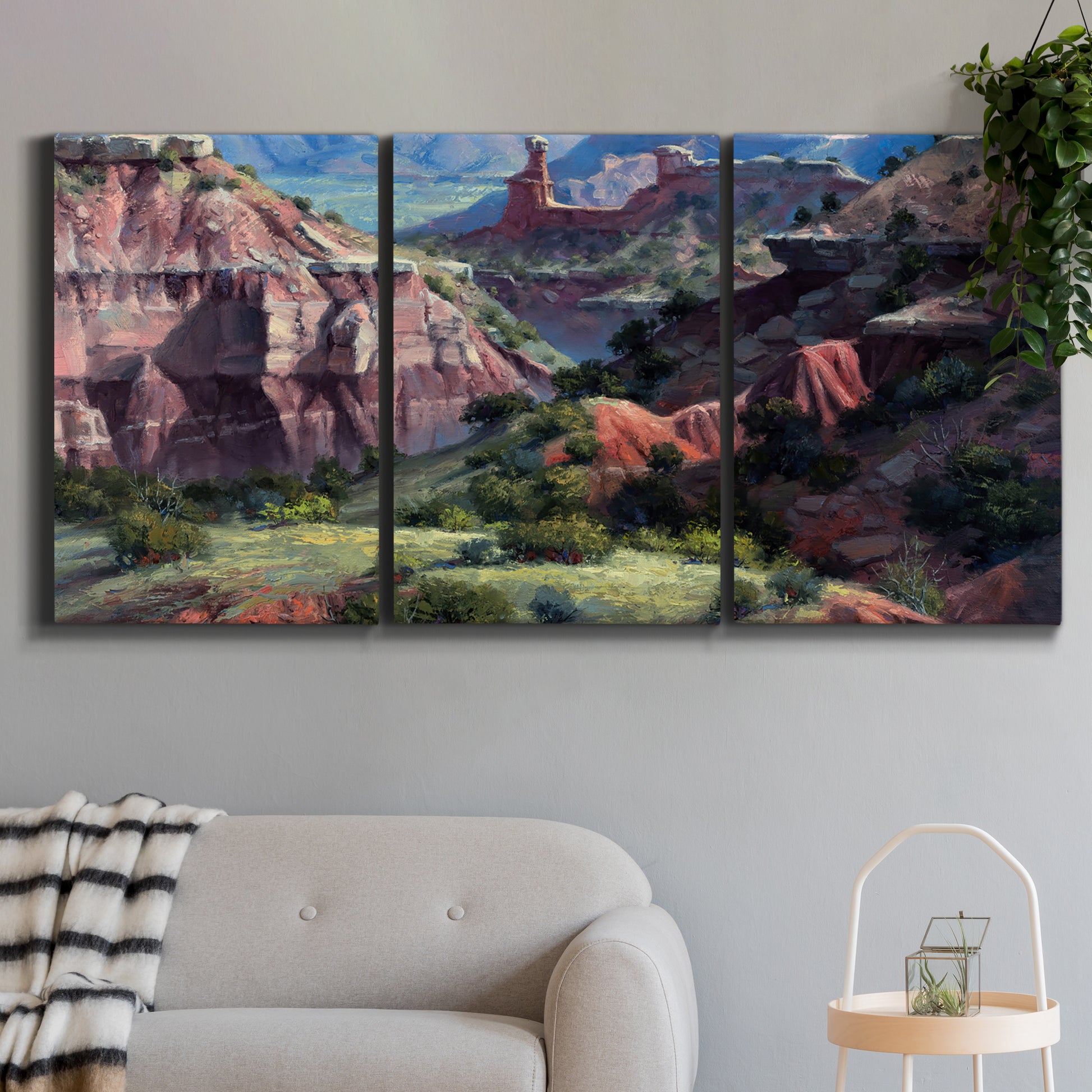 Three-panel canvas wall art featuring classic canyon landscape scene, displayed in a modern living room above a sofa.