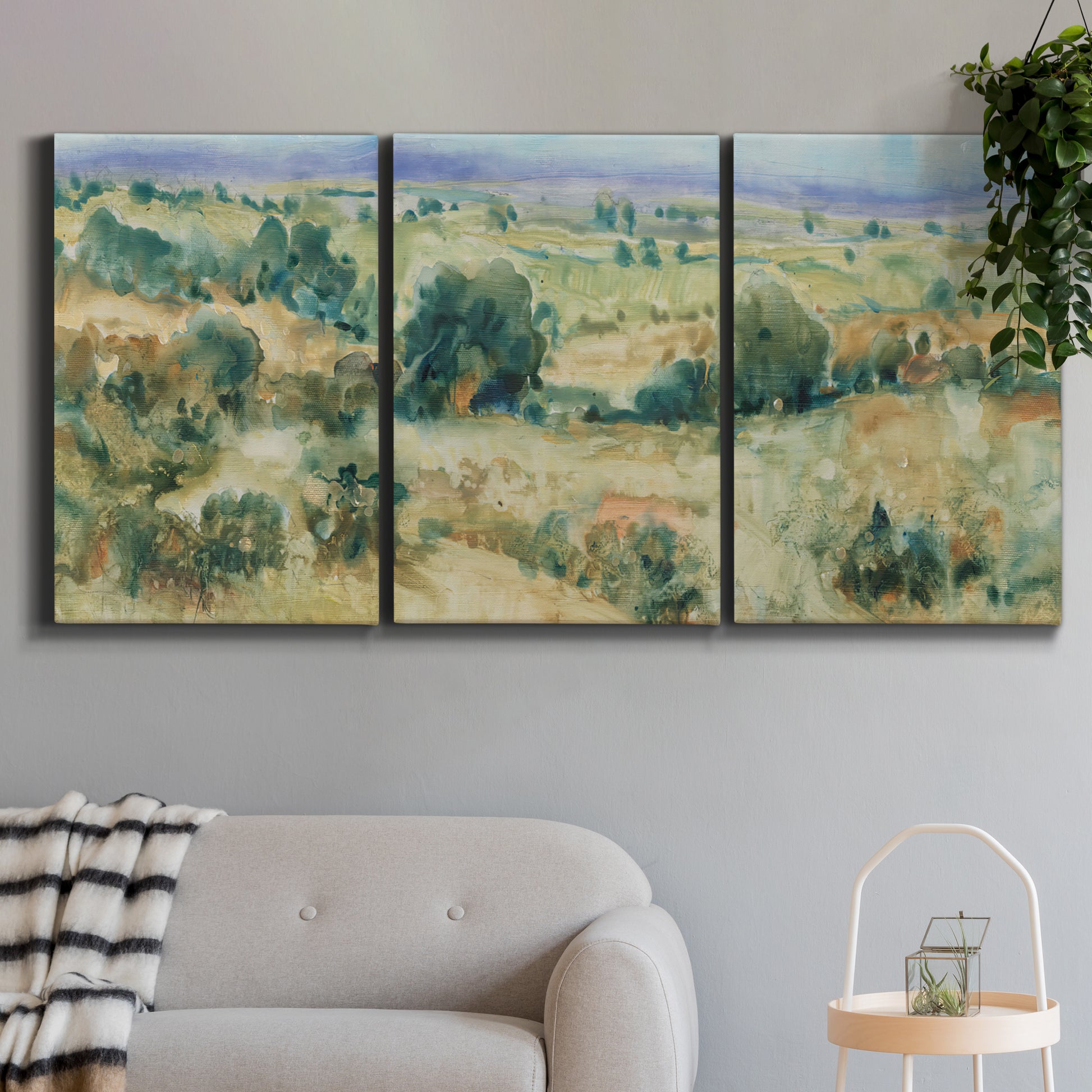 Three-panel canvas wall art featuring lavender sky over quiet landscape, displayed in a modern living room above a sofa.