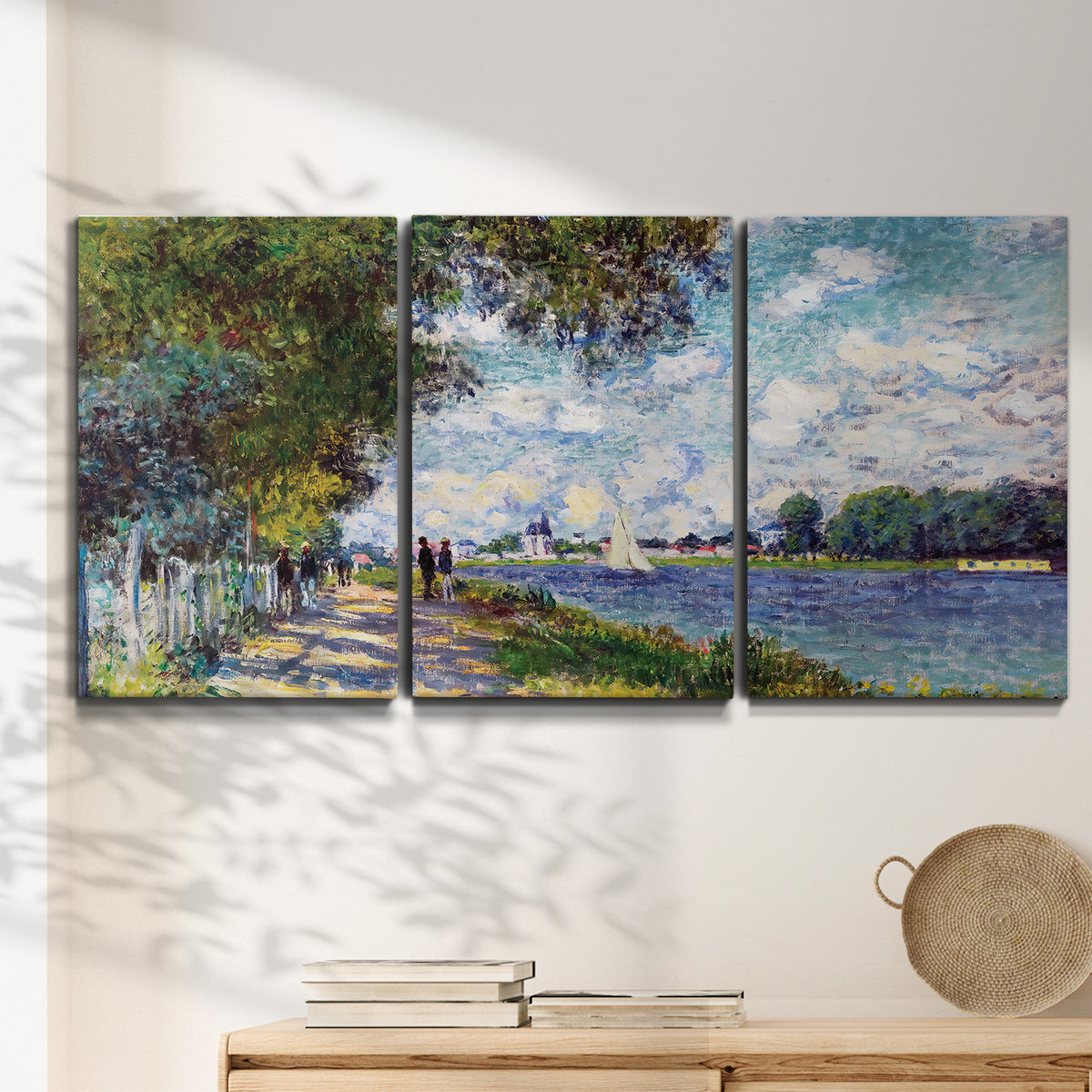 Three-panel canvas wall art featuring river landscape with boats, displayed in a minimalist living room above a console table.