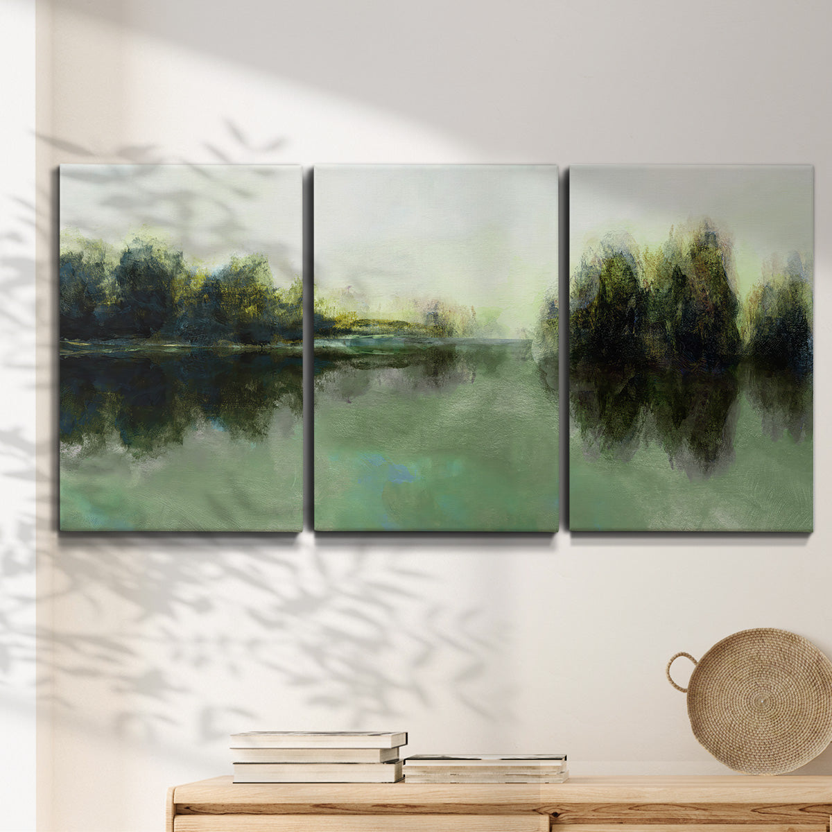 Three-panel canvas wall art featuring rain soaked landscape at sunset, displayed in a minimalist living room above a console table.