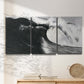 Three-panel canvas wall art featuring black and white crashing ocean waves, displayed in a minimalist living room above a console table.
