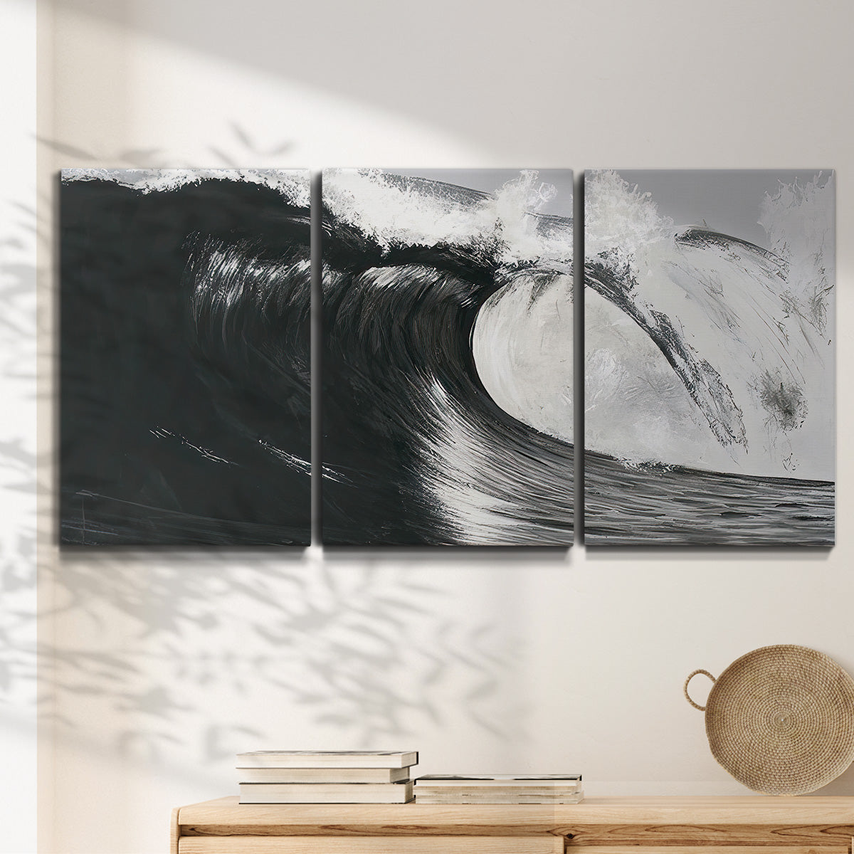 Three-panel canvas wall art featuring black and white crashing ocean waves, displayed in a minimalist living room above a console table.