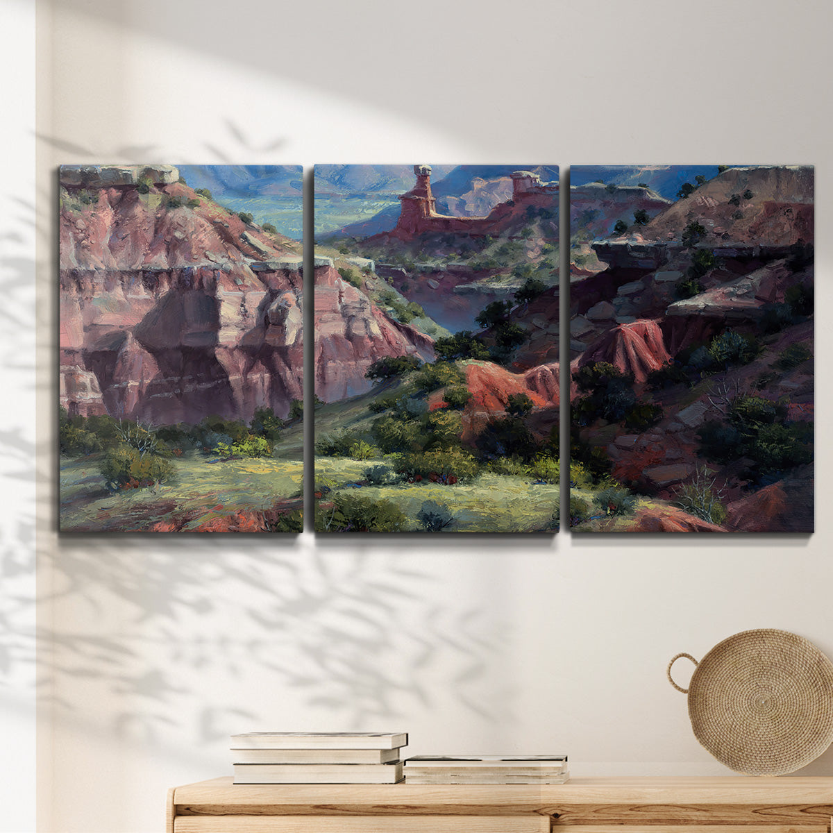 Three-panel canvas wall art featuring classic canyon landscape scene, displayed in a minimalist living room above a console table.