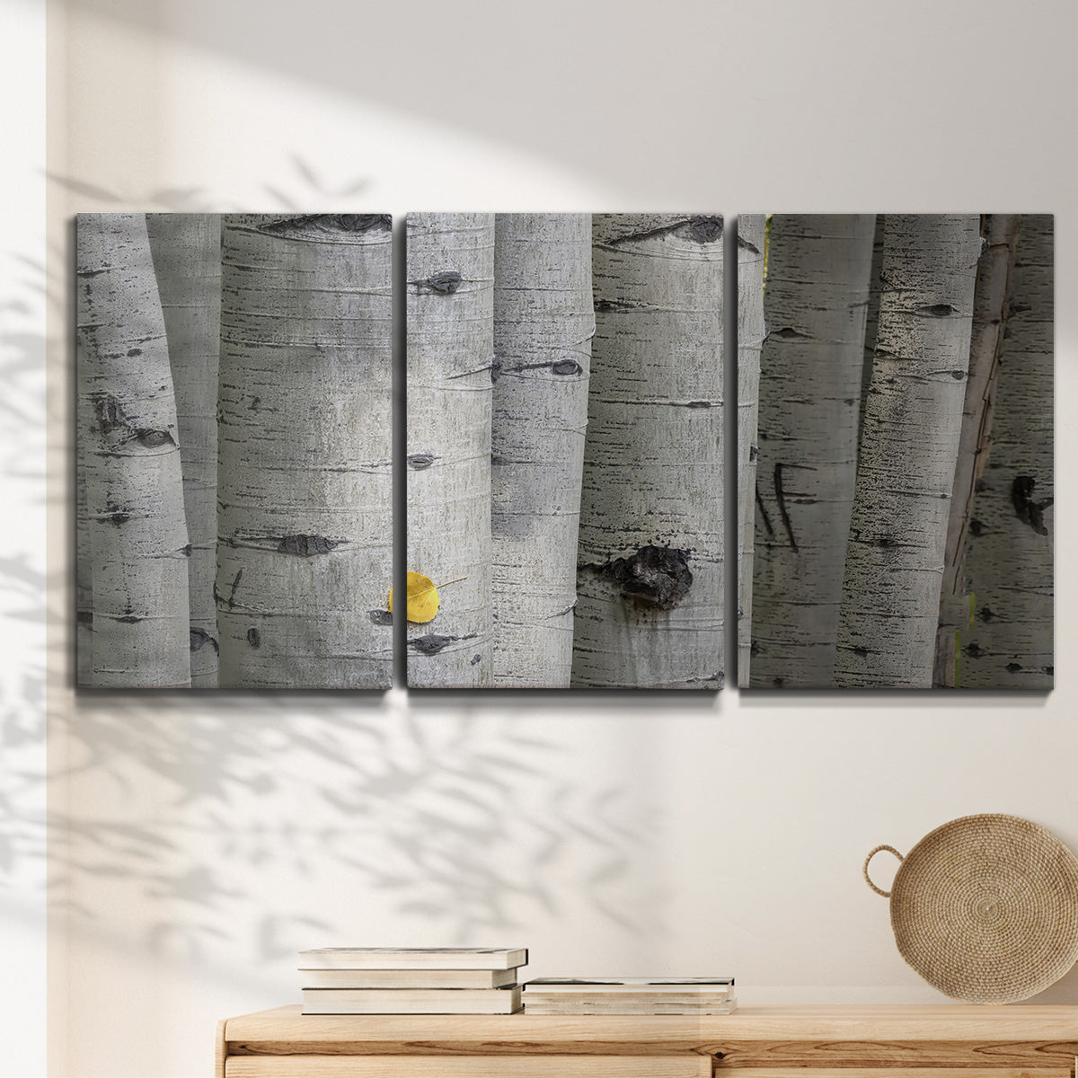 Three-panel canvas wall art featuring close up tree bark texture photograph, displayed in a minimalist living room above a console table.