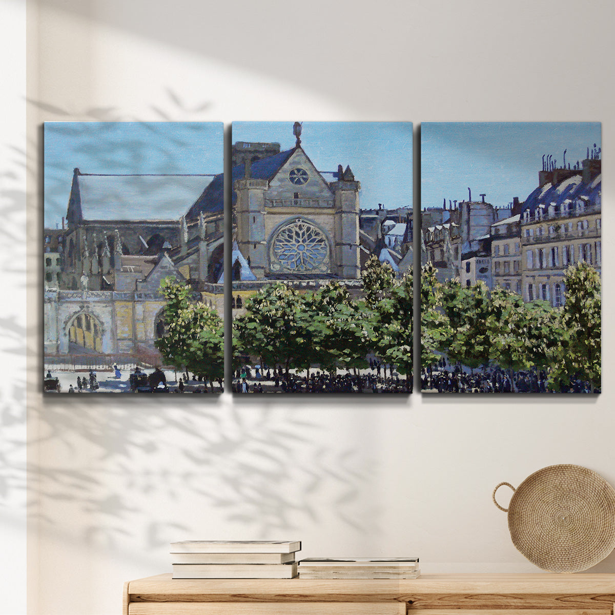 Three-panel canvas wall art featuring gothic church within city setting, displayed in a minimalist living room above a console table.
