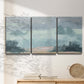 Three-panel canvas wall art featuring soft pastel valley landscape, displayed in a minimalist living room above a console table.