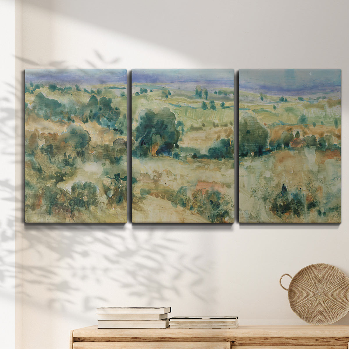 Three-panel canvas wall art featuring lavender sky over quiet landscape, displayed in a minimalist living room above a console table.