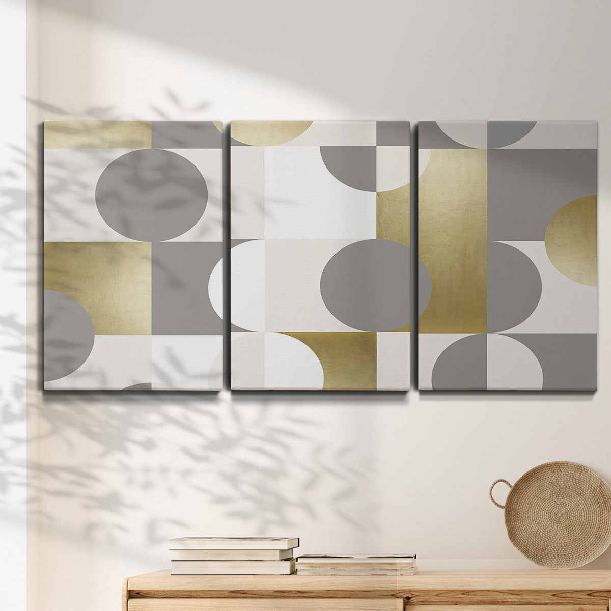 Three-panel canvas wall art featuring geometric gold abstract reflections, displayed in a minimalist living room above a console table.