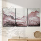 Three-panel canvas wall art featuring soft pink abstract scenic layers, displayed in a minimalist living room above a console table.