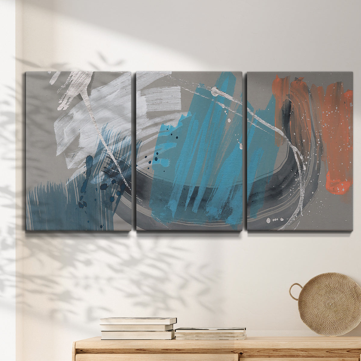 Three-panel canvas wall art featuring playful abstract mark making, displayed in a minimalist living room above a console table.