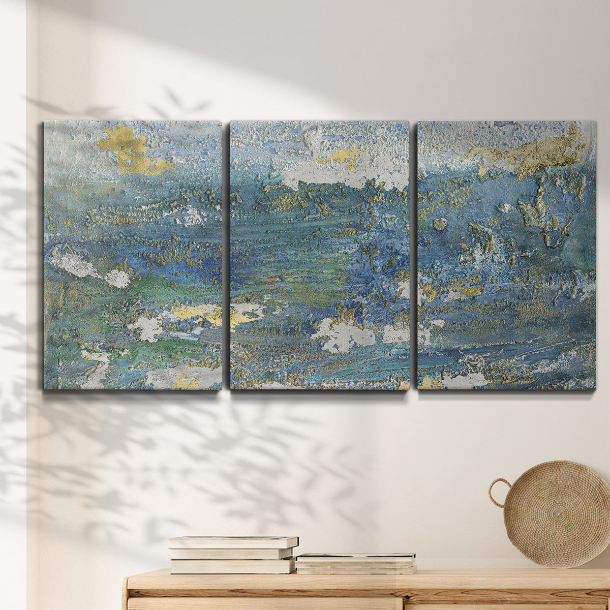 Three-panel canvas wall art featuring sparkling abstract sea surface, displayed in a minimalist living room above a console table.